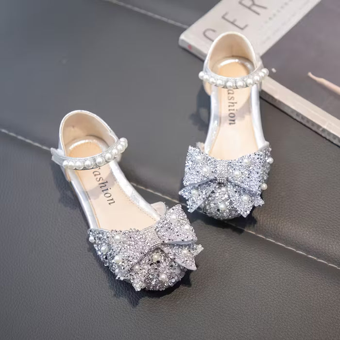 Un par de zapatos planos para niñas, adornados con pedrería