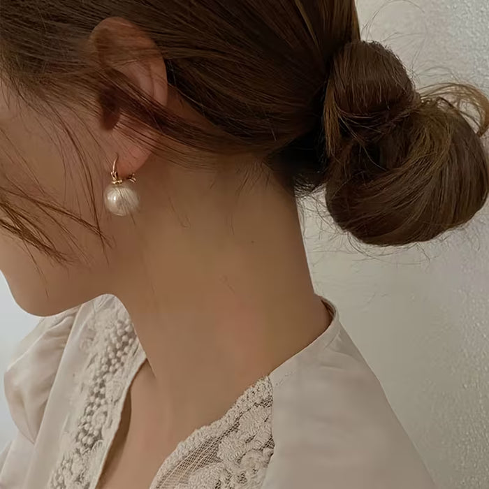 Un par de elegantes y modernos pendientes de perlas sintéticas para mujer