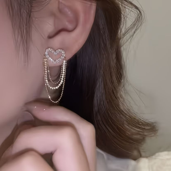 1 par de exquisitos y elegantes aretes de corazón hueco con borlas