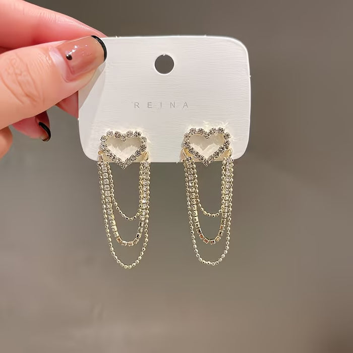 1 par de exquisitos y elegantes aretes de corazón hueco con borlas