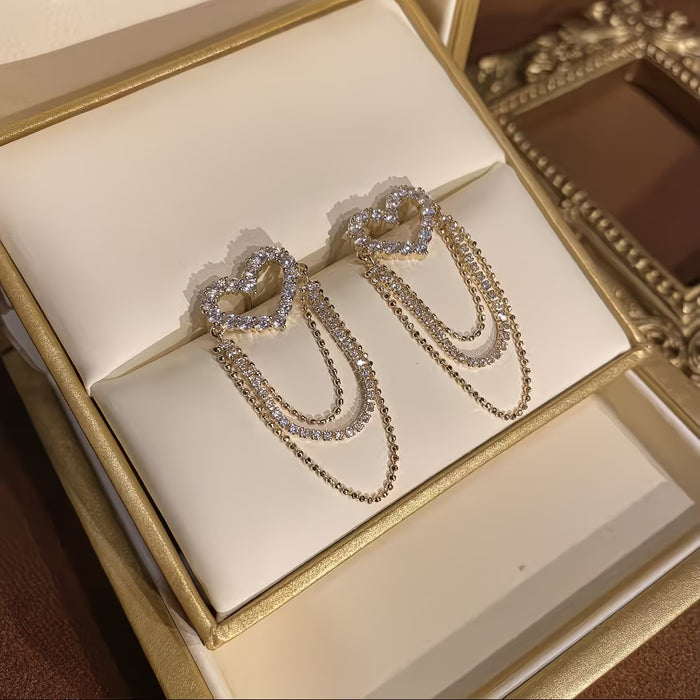 1 par de exquisitos y elegantes aretes de corazón hueco con borlas
