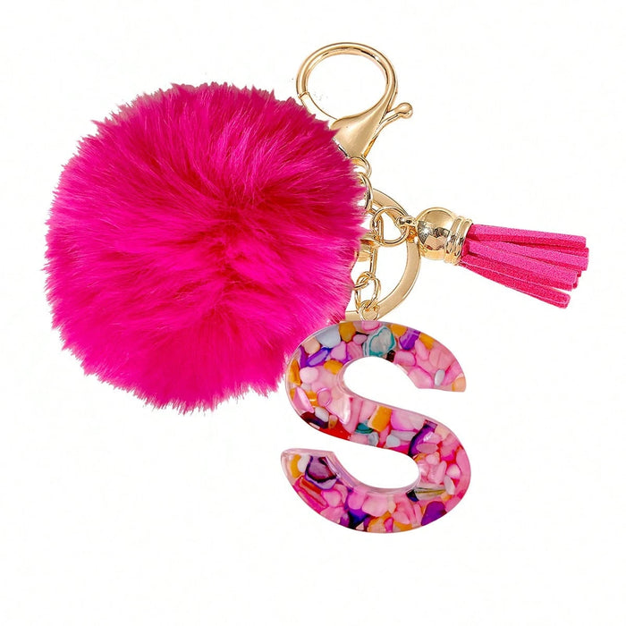 Un llavero con letra fucsia y pompón, diseñado exclusivamente para mujeres