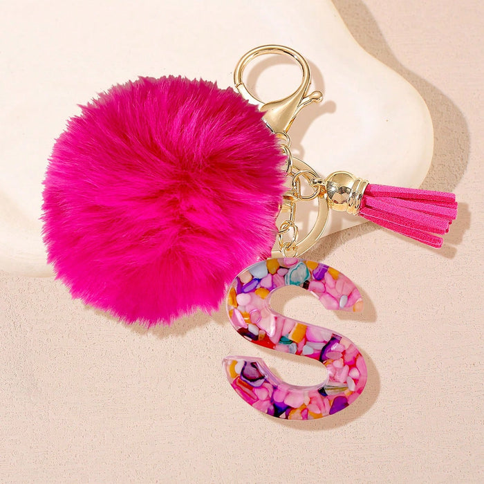 Un llavero con letra fucsia y pompón, diseñado exclusivamente para mujeres