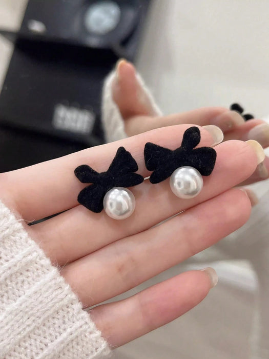 1 par de elegantes pendientes de perlas con lazo de terciopelo negro
