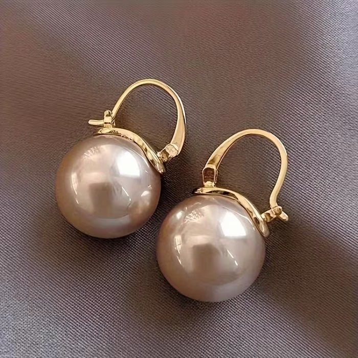 Un par de elegantes y modernos pendientes de perlas sintéticas para mujer
