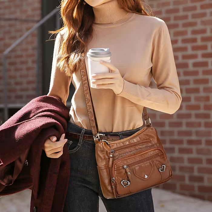 Un elegante bolso bandolera para mujer con múltiples bolsillos, de color sólido de cuero sintético
