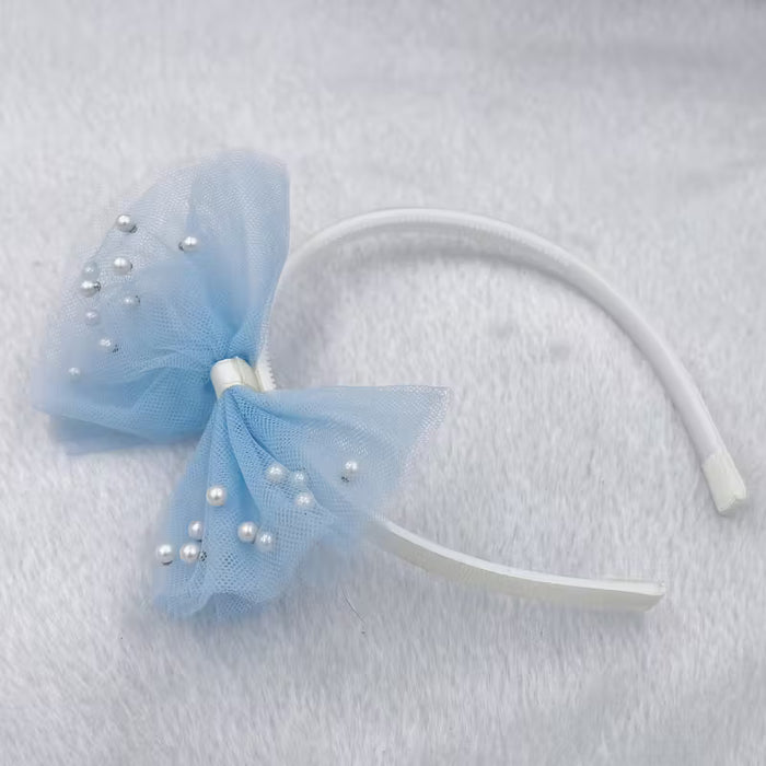 Una cinta para el cabello con un lazo, perlas y encaje