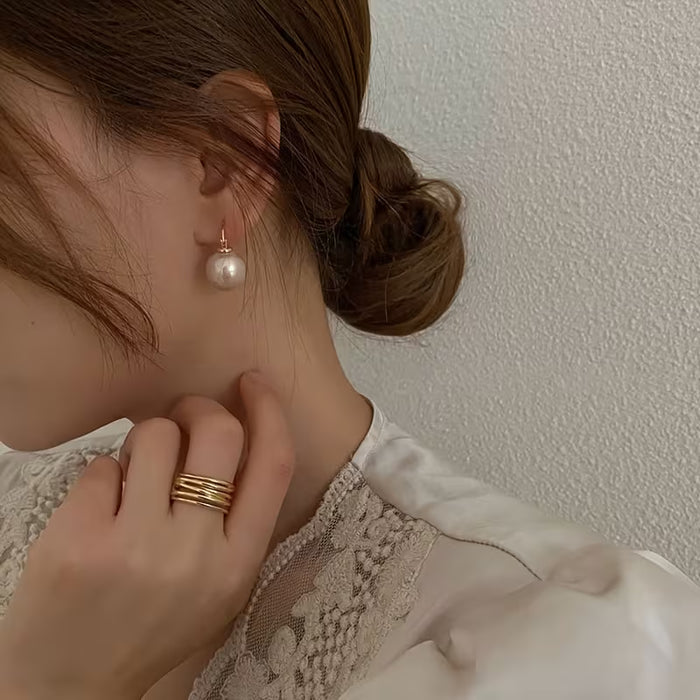 Un par de elegantes y modernos pendientes de perlas sintéticas para mujer