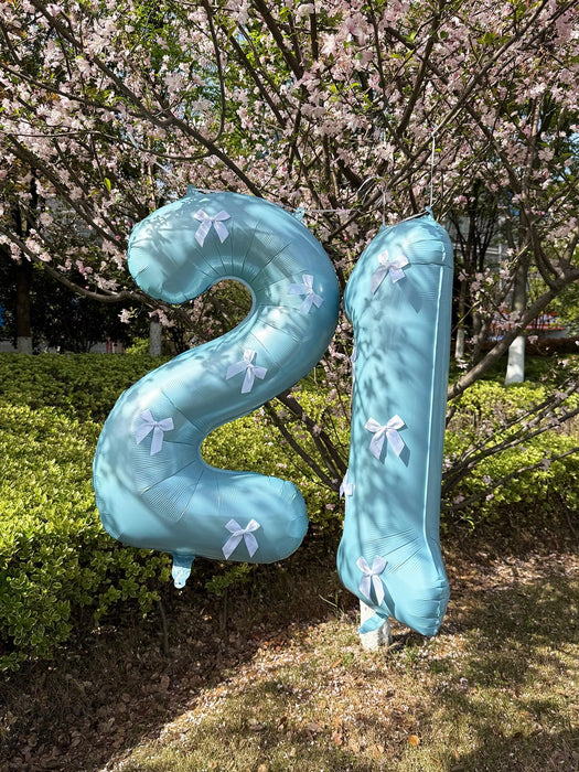 Globos de números azul claro con decoración de lazo blanco