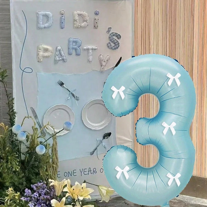 Globos de números azul claro con decoración de lazo blanco