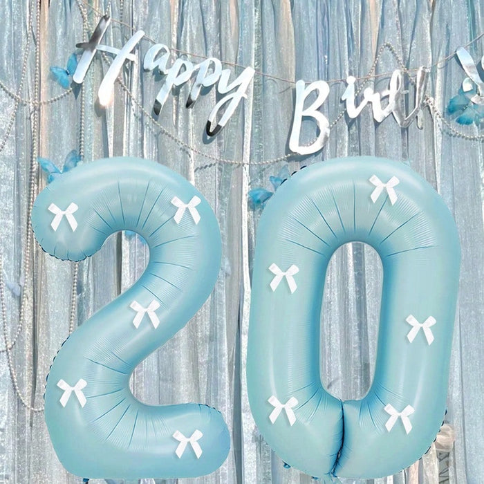 Globos de números azul claro con decoración de lazo blanco