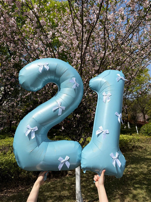 Globos de números azul claro con decoración de lazo blanco