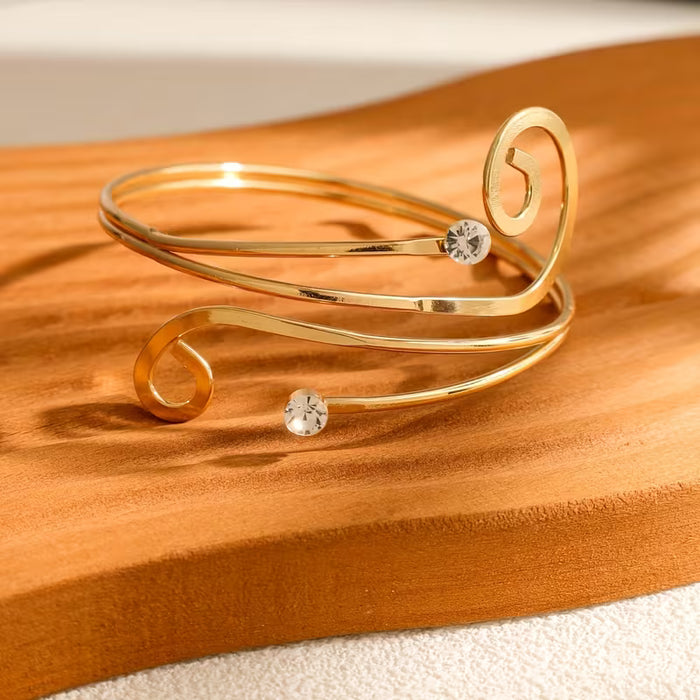 Una pulsera de metal abierta, elegante y creativa, incrustada con diamantes