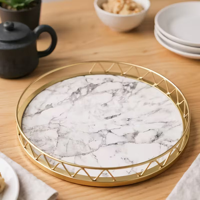 Un bandeja decorativa circular dorada, bandeja de almacenamiento y decoración para el hogar