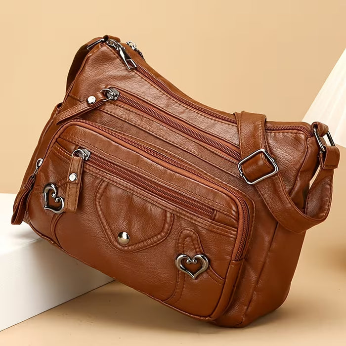 Un elegante bolso bandolera para mujer con múltiples bolsillos, de color sólido de cuero sintético