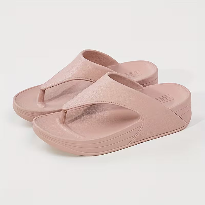 Un par de chanclas con un diseño moderno para uso en exteriores, con una suela de cuña