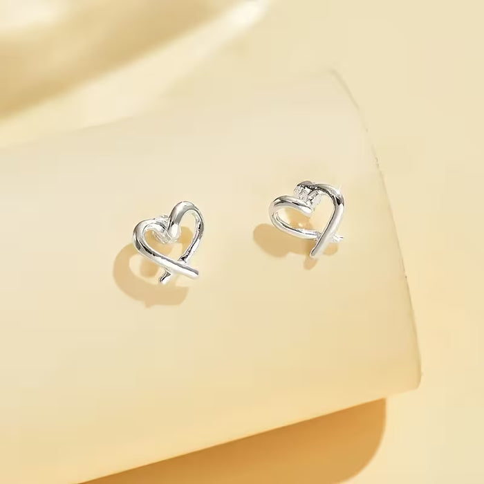 Un par de aretes de botón clásicos, elegantes, con forma de corazón