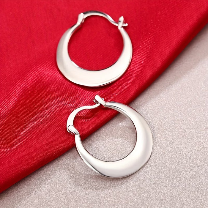Un par de aretes circulares plateados simples para mujer