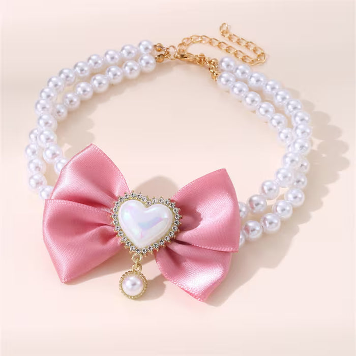 Un encantador collar de doble capa con lazo de perlas para mascotas