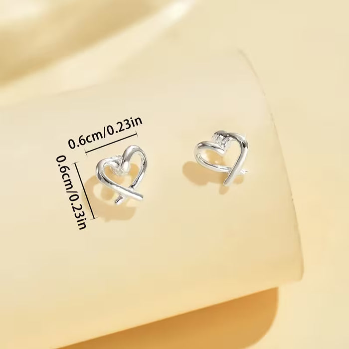 Un par de aretes de botón clásicos, elegantes, con forma de corazón