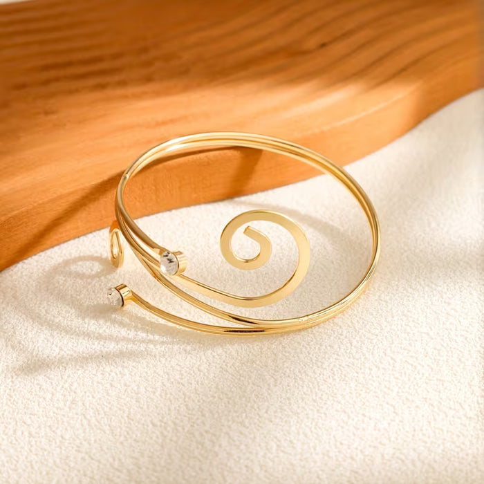 Una pulsera de metal abierta, elegante y creativa, incrustada con diamantes