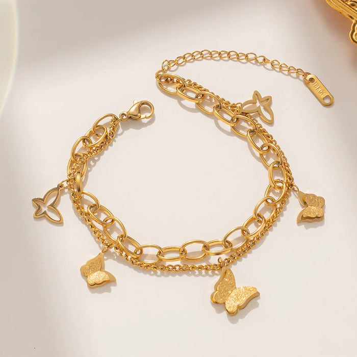 Pulsera con dijes de mariposa escarchados en color oro