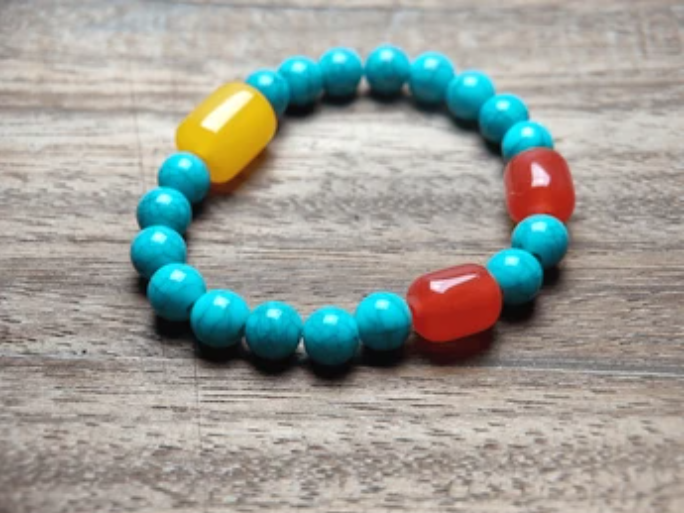 Pulsera con cuentas y elementos coloridos.