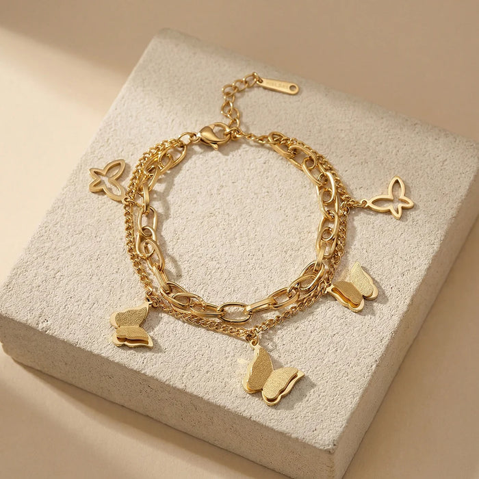 Pulsera con dijes de mariposa escarchados en color oro