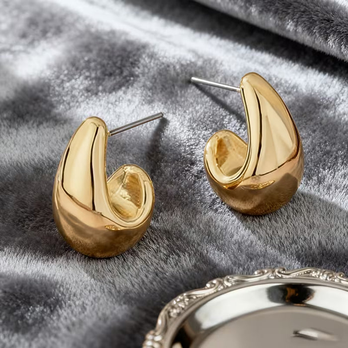 Aretes dorados huecos en forma de gota de agua, Presentan un diseño fácil pero elegante.
