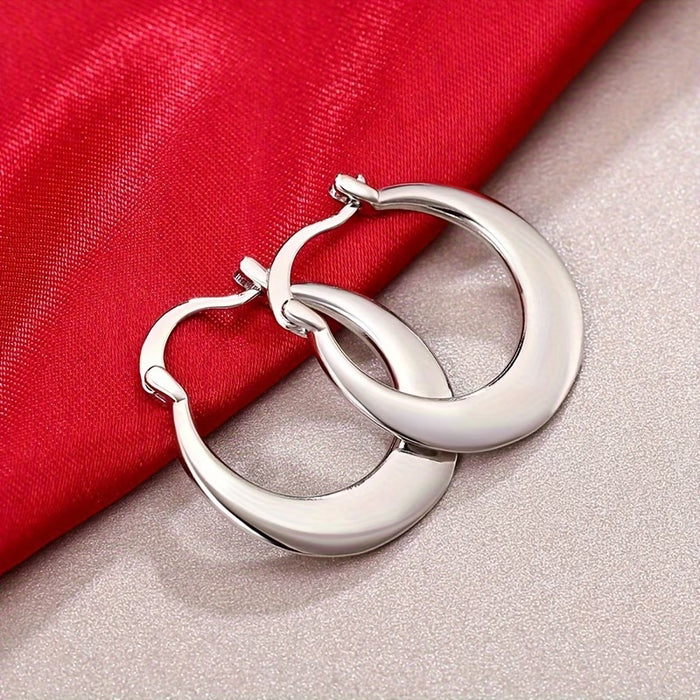 Un par de aretes circulares plateados simples para mujer