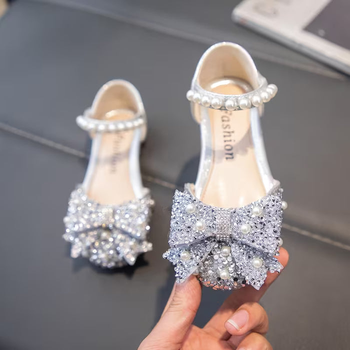 Un par de zapatos planos para niñas, adornados con pedrería