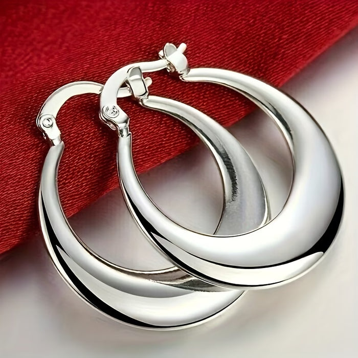 Un par de aretes circulares plateados simples para mujer
