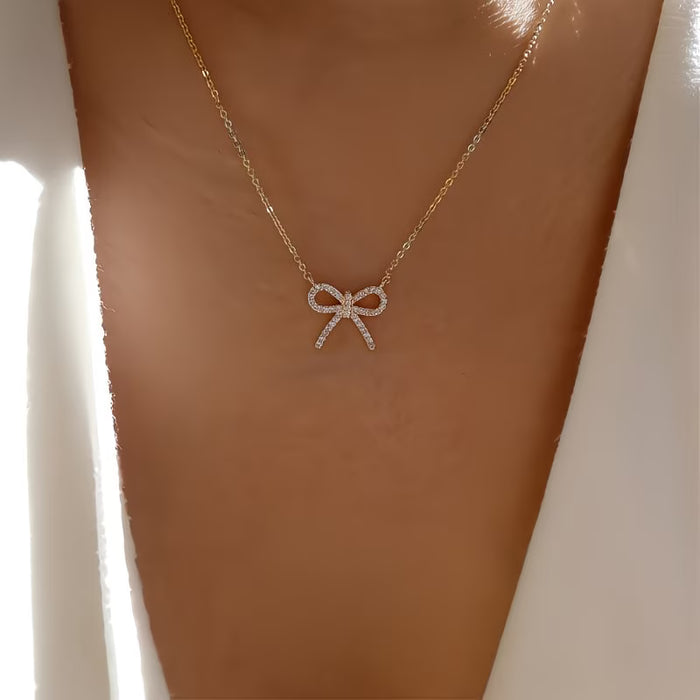 Un collar delicado para mujer con un colgante de lazo adornado con diamantes