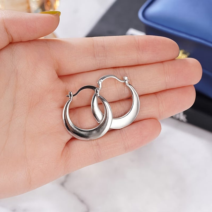 Un par de aretes circulares plateados simples para mujer