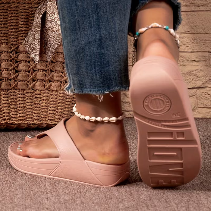 Un par de chanclas con un diseño moderno para uso en exteriores, con una suela de cuña
