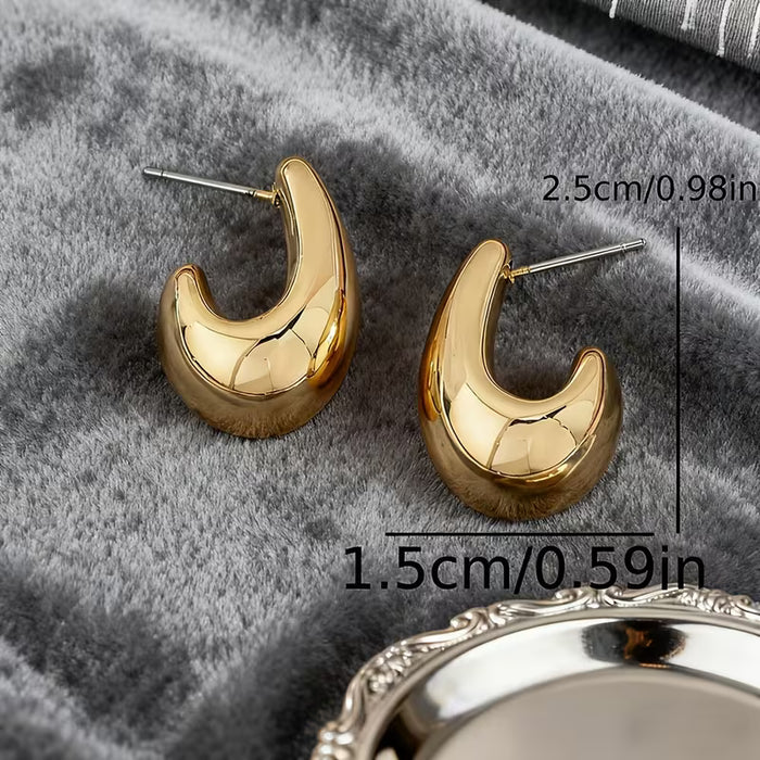 Aretes dorados huecos en forma de gota de agua, Presentan un diseño fácil pero elegante.