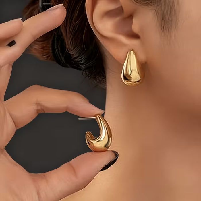 Aretes dorados huecos en forma de gota de agua, Presentan un diseño fácil pero elegante.