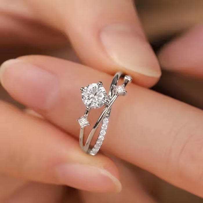 Anillo con bandas entrecruzadas y circonita sintética central, diseñado para mujer.